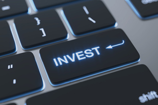 Close up image of an illuminated key on a keyboard that says "invest".