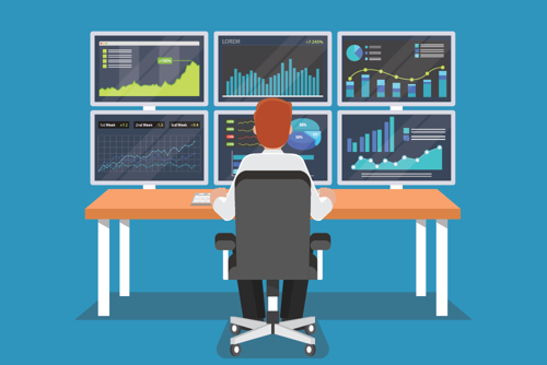 man sitting in front of multiple computer screens displaying data charts