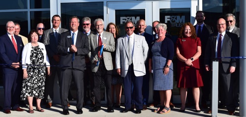 A group of people gathered for a ribbon cutting